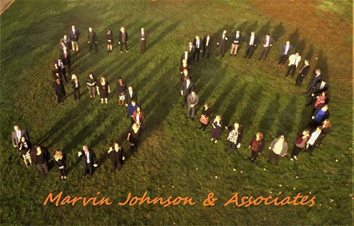 About Our Agency - Team Members of Marvin Johnson & Associates Celebrating Their 50th Anniversary by Standing in the Shape of the Number 50 in a Field on a Beautiful Day